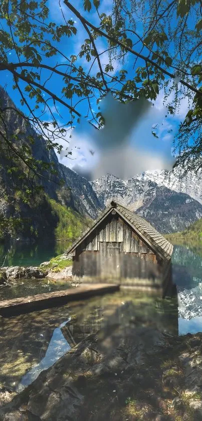 Cabin by a serene mountain lake under a clear blue sky.