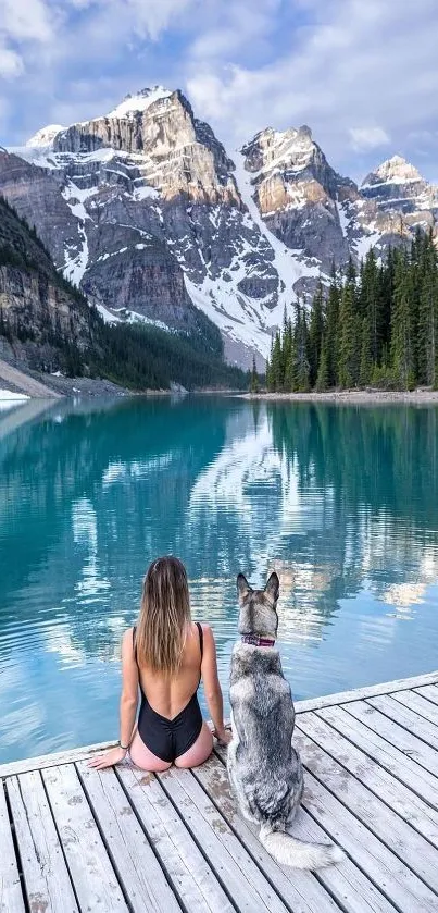 Woman and dog enjoying lake view with mountains.