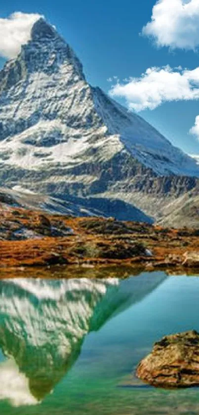 Mountain peak and lake reflection under clear blue sky.