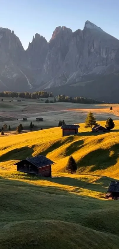 Mountain landscape with sunlight on green fields and cabins.