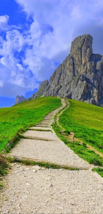 Scenic view of a mountain path under a blue sky with green grass.