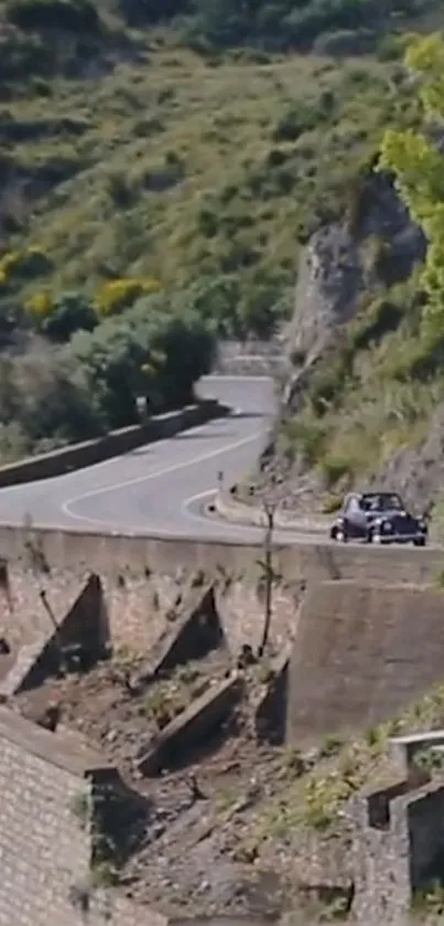 Classic car on winding mountain road with lush green surroundings.