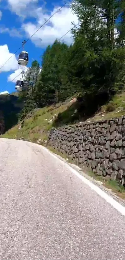 Scenic mountain road with cable cars and lush greenery.