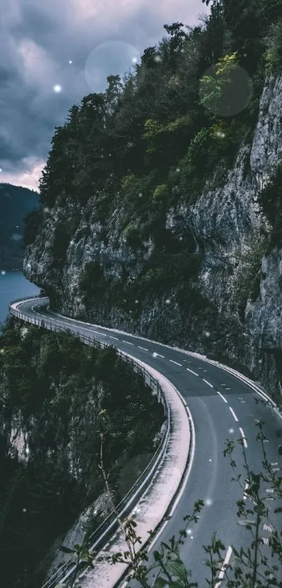 Scenic winding road on mountain edge with cloudy sky and lush scenery.