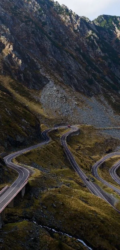 Curvy mountain road winding through rugged terrain under clear skies.