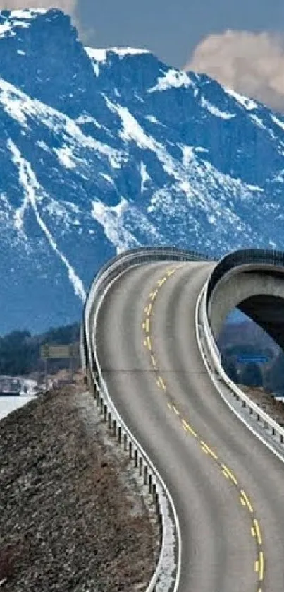 A scenic mountain road with winding curves and snowy peaks in the background.