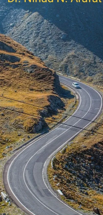 Scenic mountain road winding through rocky terrain under clear blue skies.