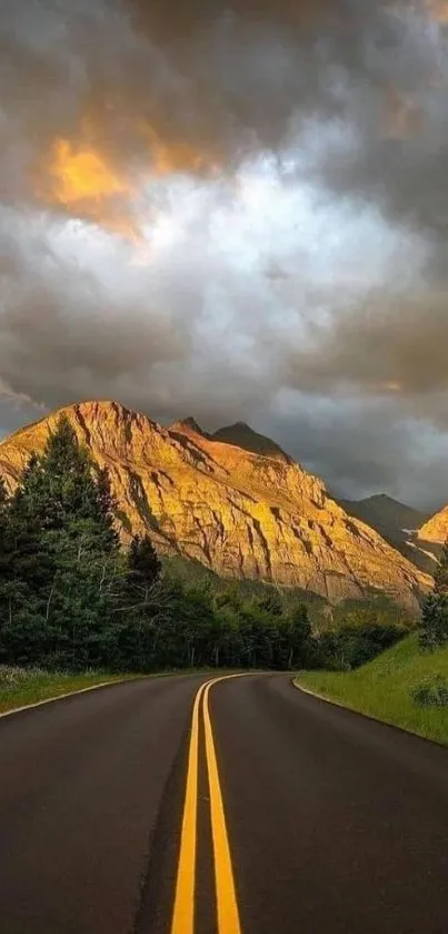 Mountain road with dramatic skies and illuminated peaks wallpaper.