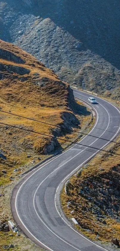 Winding road through mountains under a blue sky.