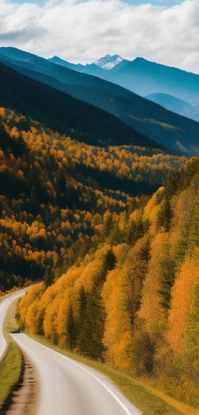 Winding road through vibrant autumn forest and mountain range.