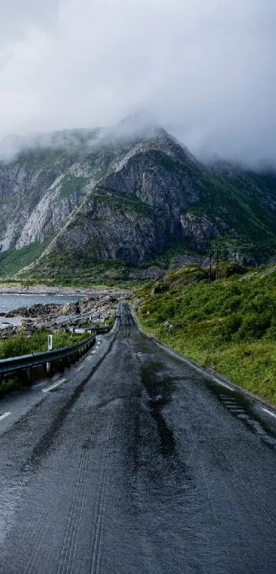 Misty mountain road with lush greenery and moody clouds.