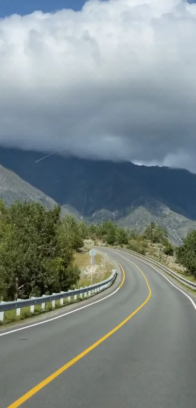 Scenic winding road through lush mountains under a cloudy sky.