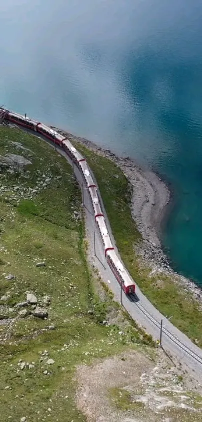 Red train traverses lush mountain beside blue lake.