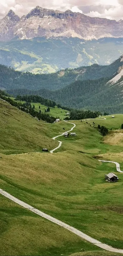 A scenic view of a green mountain valley with a winding path and distant peaks.