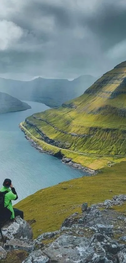 Person taking photos of a lush green valley and mountains.