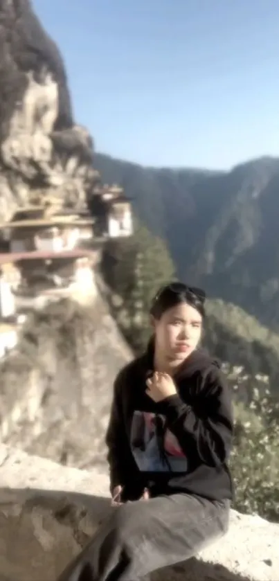 A person sits peacefully against a scenic mountain backdrop.