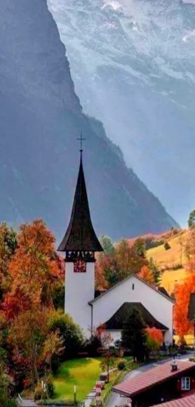 Scenic autumn village with church under a foggy mountain backdrop.