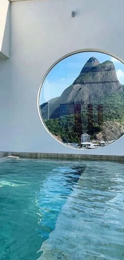 Circular window with mountain view and pool.