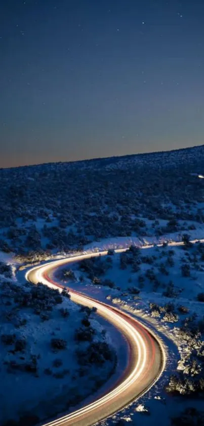 Winding road under starry night in snowy landscape.