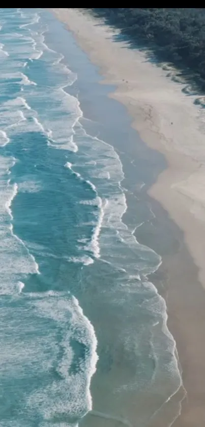 Aerial view of ocean waves crashing on a serene beach.