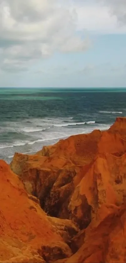 Scenic view of orange cliffs by the ocean with a calm blue sky.