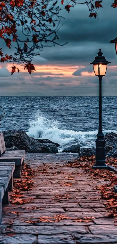 Ocean sunset with stone path and street lamps in autumn.