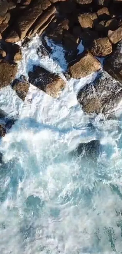Top view of ocean waves crashing against rocky shore.