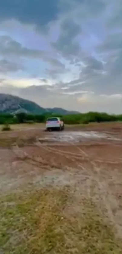 Off-road vehicle on scenic terrain with mountain backdrop.