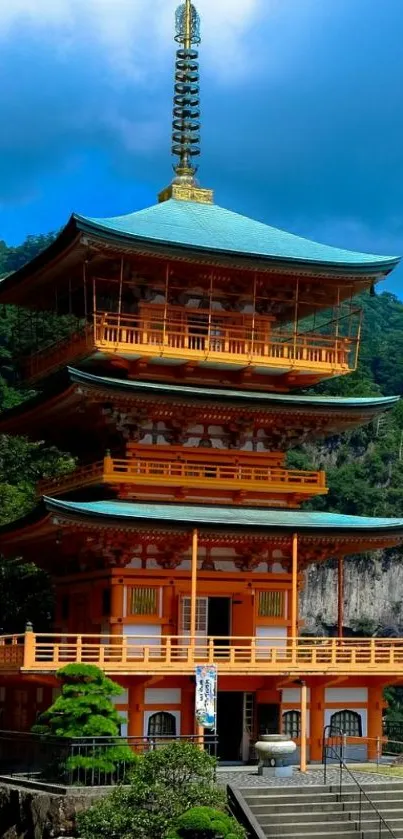 Traditional Japanese pagoda with lush mountain backdrop.