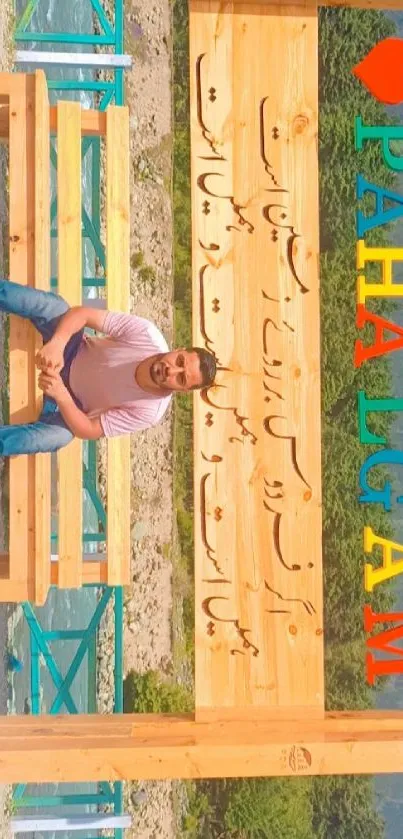 Bench with colorful Pahalgam sign and mountain view background.