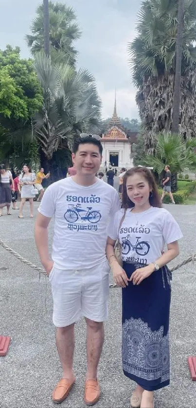 Couple enjoying a stroll in a scenic park with lush green background.