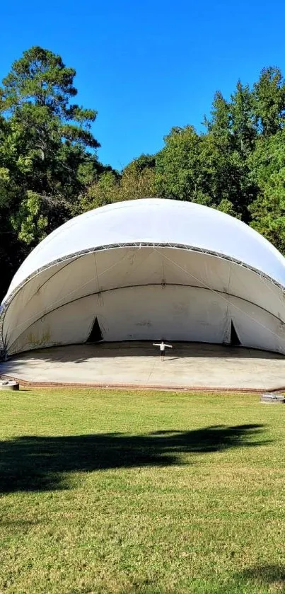 White dome in a green park under a blue sky.