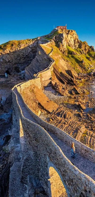 Scenic coastal pathway with rocky cliffs under a vibrant blue sky at sunset.