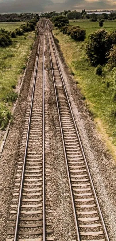 Scenic railway tracks with green fields and cloudy sky