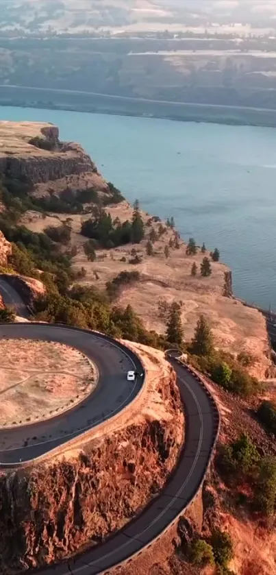 Scenic view of a winding road along a river bend amidst rugged cliffs.