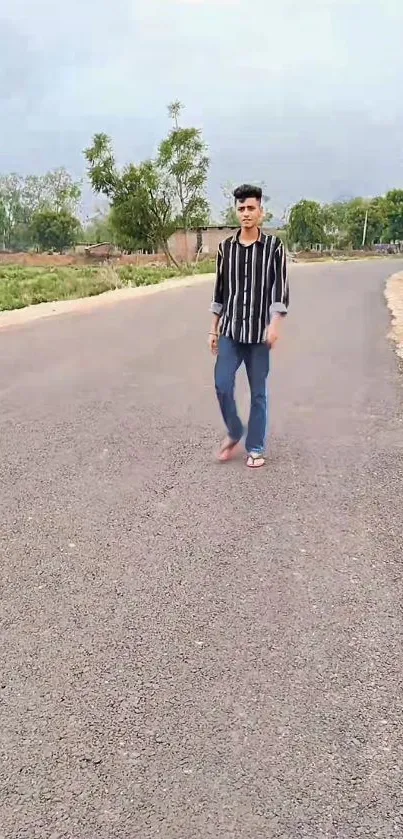 Person walking down a scenic, empty road surrounded by greenery.