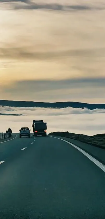 Scenic road with misty mountains and serene sky, perfect for mobile wallpaper.