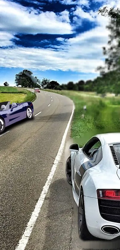 Sports cars on a scenic, curving countryside road.