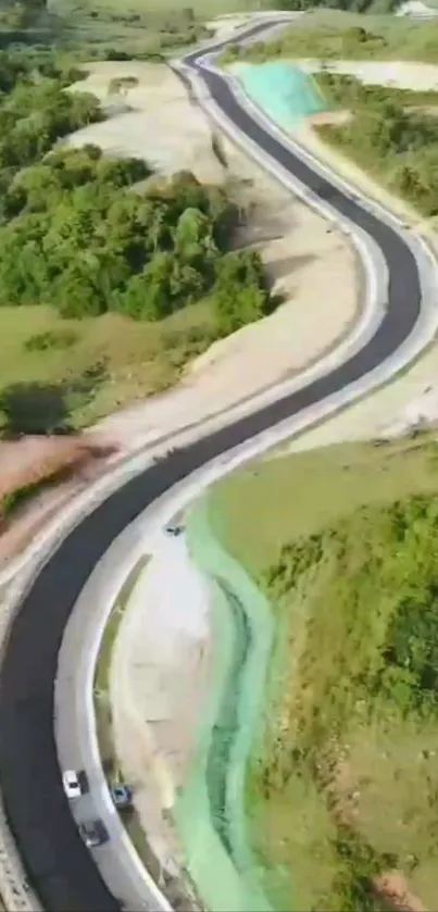 Aerial view of a winding road through lush greenery and landscapes.