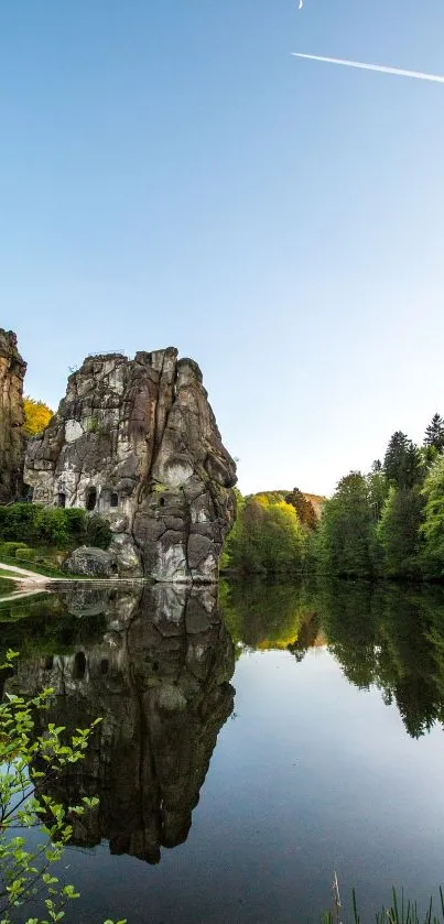 Reflective rock landscape with blue sky and serene lake.