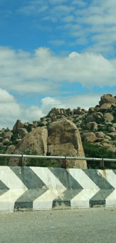 Scenic view of rocky hillside under a vivid blue sky with fluffy clouds.