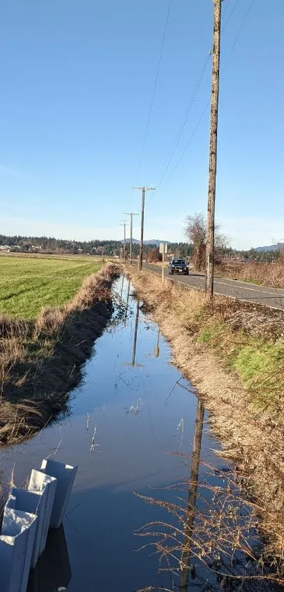 Serene rural road with clear sky reflection.