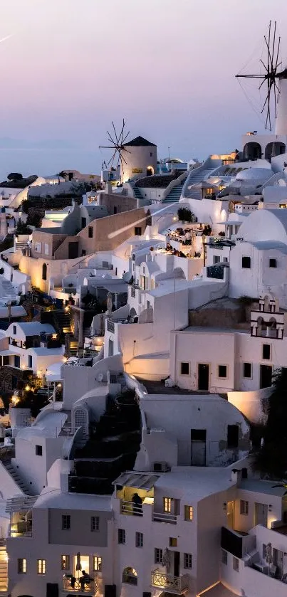Enchanting Santorini evening view with white houses and windmills.
