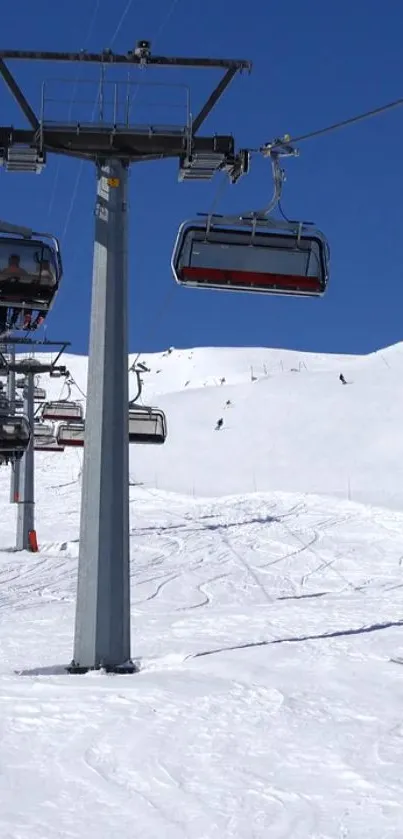 Ski lift ascending snowy mountain under clear blue sky.