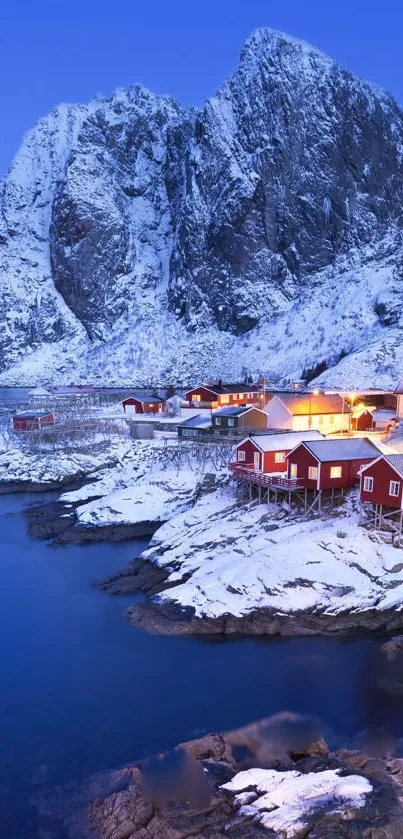 Snowy mountain with red cabins at dusk.