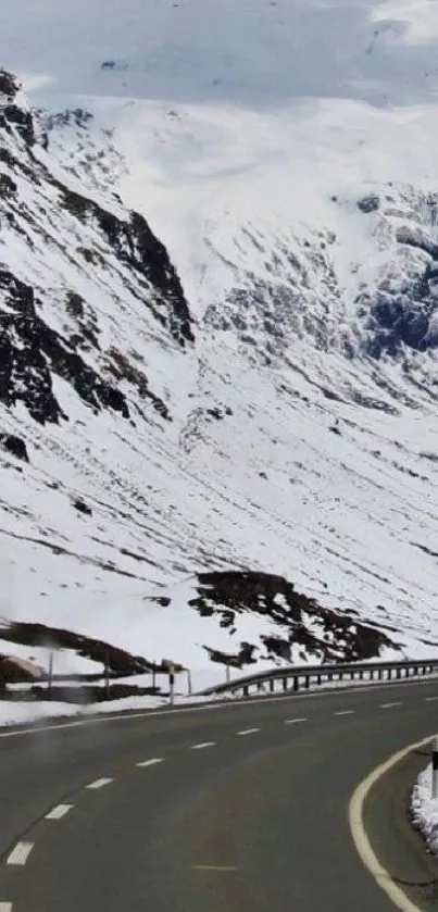 A winding road through snow-covered mountains on a tranquil winter day.