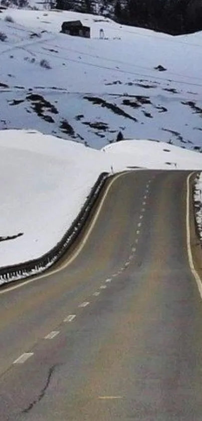 Winding road through a snowy mountain landscape wallpaper.