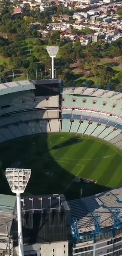 Aerial view of a large stadium with green surroundings and clear sky.