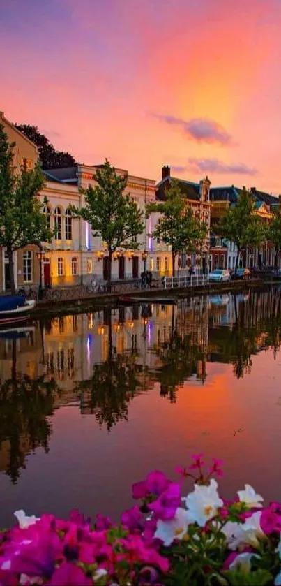 Sunset over canal with blooming flowers and charming architecture.