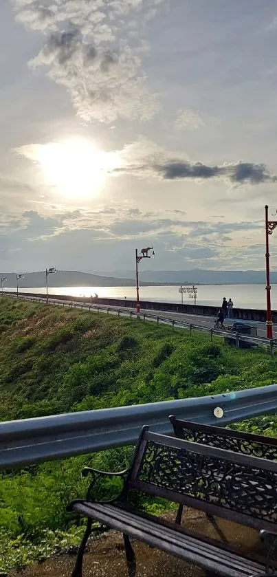 Scenic view of a sunset over a roadway with benches and greenery.